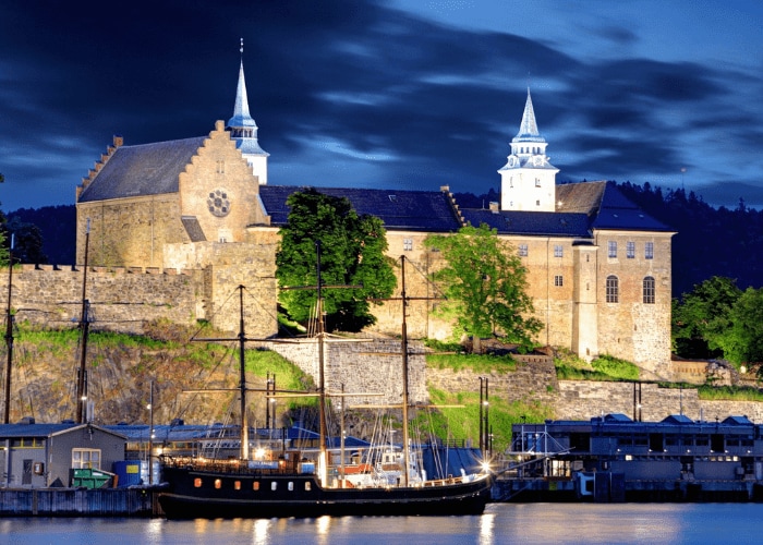 a traveler photographing intricate carvings on an ancient temple's facade.